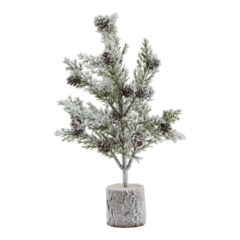 snowy small snowy fir tree with pinecones in wood log