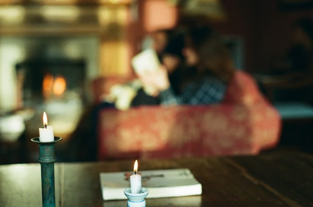 Candles glowing on a table in a warm living room